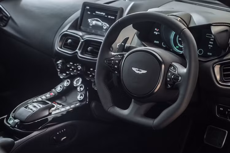 Khoang lái Vantage cũng được tô điểm bằng các đường chỉ thêu đỏ. Logo của hãng xe Anh Quốc được thêu màu đỏ. Màu đen vẫn là tông màu chủ đạo.