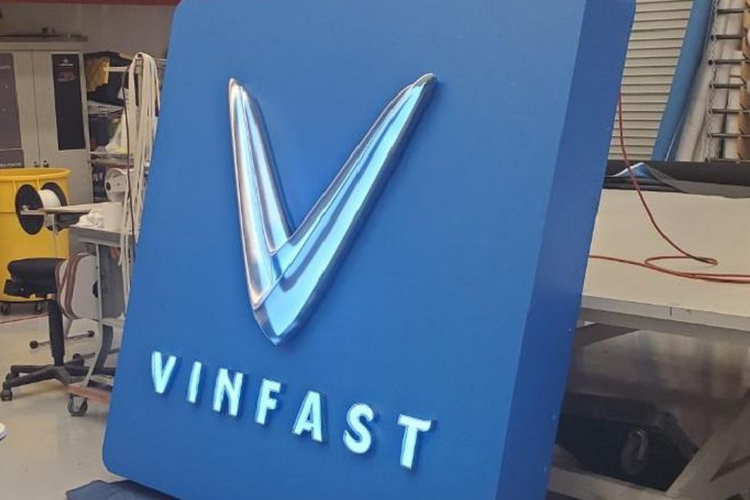 HÌnh ảnh logo của VinFast chuẩn bị được treo lên tại LA Auto Show 2021. Chữ V quen thuộc cùng màu xanh dương đặc trưng của VinFast được giới truyền thông quốc tế ví như một “tia điện xanh” tràn đầy năng lượng. 