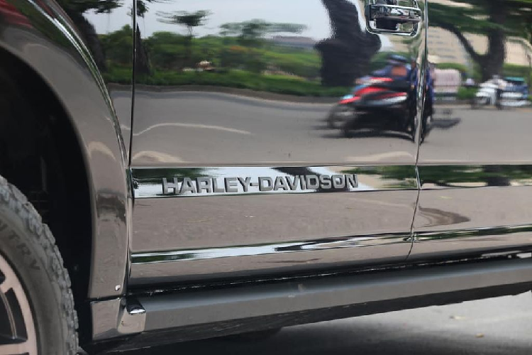 Đầu tiên có thể kể tới như mặt ca-lăng to bản sơn đen viền đỏ cá tính được làm mới kết hợp với dải đèn Led phụ gắn thêm vào cản trước, hốc gió trên nắp ca-pô, ống trang trí, vòm bánh xe mới, móc kéo xe... Phiên bản Harley-Davidson còn được trang bị bộ mâm kích thước 22 inch kiểu khiên la mã cực kỳ ấn tượng và không thể nhầm lẫn.