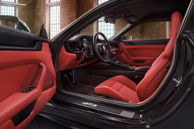 Trong khi đó, nội thất của 911 GT3 Touring đời mới được bọc da Exclusive Manufaktur 2 tông đen - đỏ cá tính. Những mảng da màu đỏ giúp không gian cabin xe trở nên sống động hơn hẳn, tạo sự khác biệt với vẻ ngoài hầm hố.