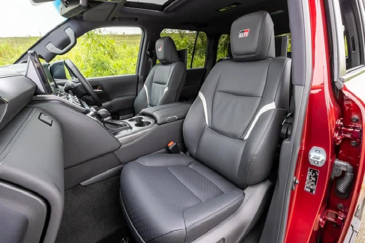 Nội thất của GR Sport kết hợp da đen và đỏ sẫm. Biểu tượng của Gazoo Racing trên chìa khoá, vô lăng, tựa đầu ghế ngồi và trên màn hình thông tin giải trí 12,3 inch.