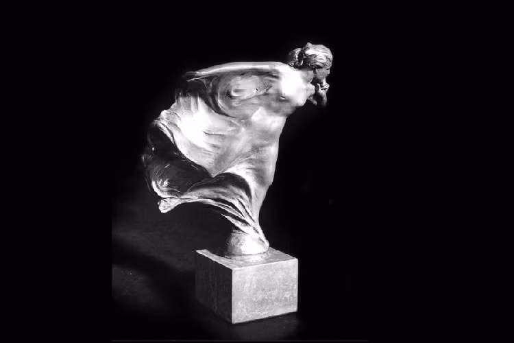 Được biết, cảm hứng thiết kế của Spirit of Ecstasy xuất phát từ một bức tượng bằng đồng do nhà điêu khắc kiêm họa sĩ vẽ tranh minh họa Charles Sykes thực hiện. Bức tượng đó có tên là Whisper và nó được tạo ra cho Lord Montagu of Beaulieu, một nhà tiên phong trong lĩnh vực ôtô và là người đầu tiên sử dụng Rolls-Royce.