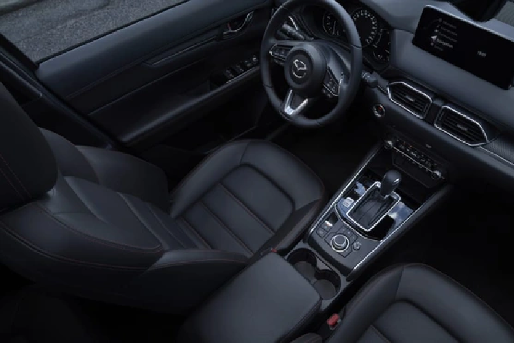 Bên trong Mazda CX-5 2022 không có nhiều thay đổi. Tại thị trường Mỹ, mẫu SUV cỡ C này có sạc điện thoại thông minh không dây chuẩn Qi trên cụm điều khiển trung tâm, nút chọn chế độ lái Mi-Drive mới và ghế thiết kế lại để tăng sự thoải mái hơn cho người ngồi. Bên cạnh đó là màn hình thông tin giải trí dạng cảm ứng 10,25 inch như cũ.