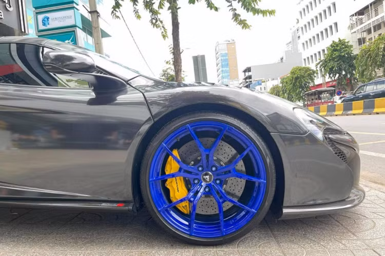 Việc "phủ carbon" cho ngoại thất chiếc xe McLaren 650S Spider đã gây ấn tượng mạnh với giới mê xe. Không chỉ thế, siêu xe mui trần này còn sở hữu bộ la-zăng độ rất nổi bật với tông màu xanh dương cá tính, đối lập bộ áo carbon bằng đề-can. La-zăng độ 5 chấu kép của chiếc McLaren 650S Spider của hãng Vossen với cùm phanh sơn vàng