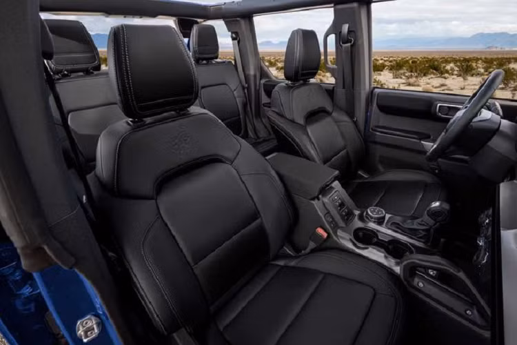 Đối với tùy chọn Black Onyx, nội thất SUV địa hình Ford Bronco First Edition được bọc trong da Vinyl mang đến cảm giác thoáng mát hơn cho người ngồi. Các đường chỉ khâu màu bạc, xám tương phản trên ghế, cánh cửa, bảng điều khiển trung tâm, dây đai an toàn, táp-lô giúp tạo điểm nhấn cho không gian trong xe.