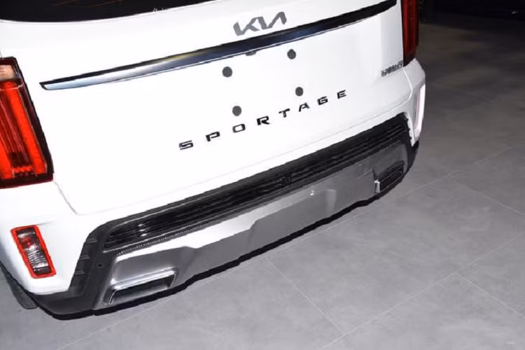 Trên đầu xe, Kia Sportage Ace 2021 bản thường được trang bị lưới tản nhiệt "mũi hổ" đặc trưng, có kích thước lớn và không viền. Bên trong lưới tản nhiệt là xuất hiện những nan mạ crôm thanh mảnh và nằm dọc, gợi liên tưởng đến thác nước. Nằm giữa lưới tản nhiệt này sẽ là logo mới của hãng Kia. Ngay bên trên lưới tản nhiệt là nẹp mạ crôm ôm lấy nắp ca-pô.