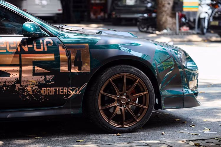 Bắt đầu từ ngoài thất, chiếc Toyota Celica độ siêu độc này khoác lên mình một lớp sơn xanh ngọc bích tối màu mới với những chi tiết decal độc đáo. Bộ bodykit độc quyền được trang bị cho xe. Ở phía sau, đèn hậu có thiết kế tương tự các mẫu xe cơ bắp của Dodge. Dàn pô on-off “full cây” và chụp pô đôi hiệu Akrapovic được trang bị cho xe.