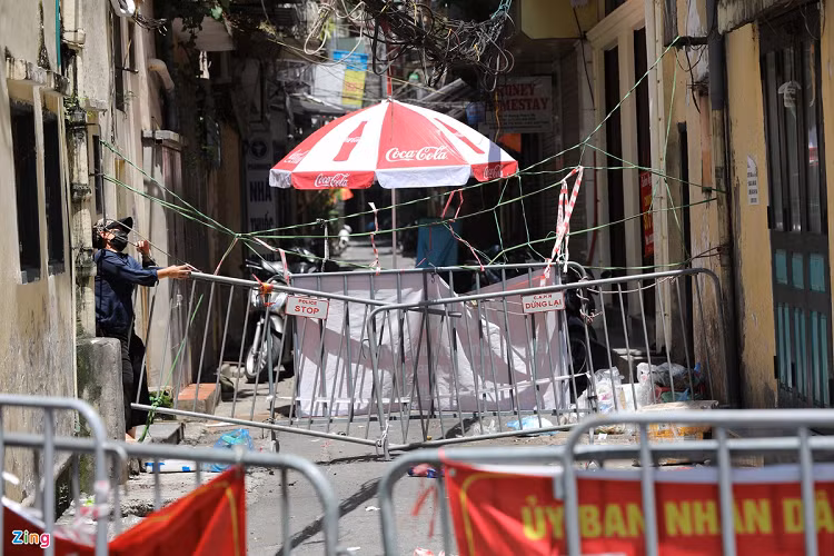 Cách ngõ Phất Lộc chưa đầy 1 km là ngõ Tạm Thương, quận Hoàn Kiếm. Nơi đây một rào chắn của lực lượng chức năng dựng lên vẫn chưa đủ, người dân còn gia cố thêm một lớp ngăn cách phía trong. 