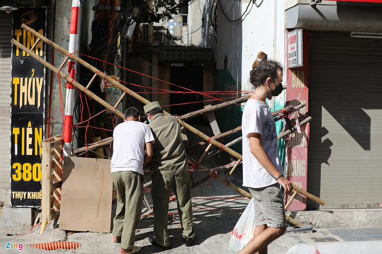 Tại ngõ 380 Thụy Khuê, người dân và lực lượng dân phòng dùng thang, dây và tấm bìa carton để rào một cách kín nhất có thể.