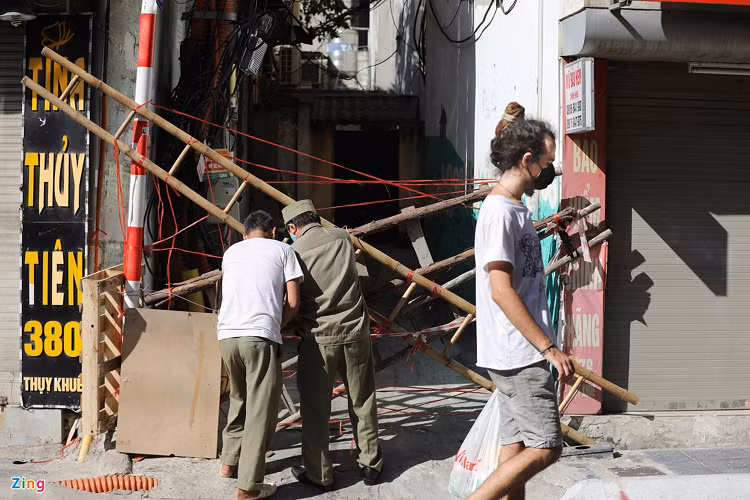 Tại ngõ 380 Thụy Khuê, người dân và lực lượng dân phòng dùng thang, dây và tấm bìa carton để rào một cách kín nhất có thể.