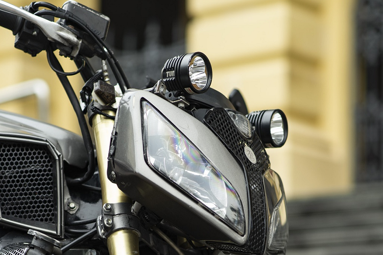 Ở đầu xe, 2 phần chóa đèn bên trong được giữ lại và bọc bằng vỏ kim loại, tách rời nhau, khiến chiếc xe trông dữ dằn hơn khi nhìn trực diện. Để tăng sáng cho cặp đèn nguyên bản, chiếc xe được trang bị thêm cặp đèn LED. Gương chiếu hậu gắn 2 bên gù tay lái.