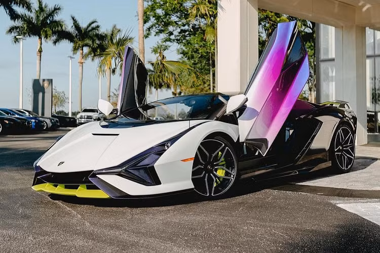So với những chiếc siêu xe Lamborghini Sian xuất hiện trước đó, siêu phẩm triệu đô hybrid mới có mặt tại đại lý Lamborghini Broward trước khi được bàn giao cho chủ nhân sở hữu bộ áo 3 màu chính là trắng, tím và đen của sợi carbon. Chưa dừng lại đó, ở ngoại thất của chiếc siêu xe triệu đô hybrid Lamborghini Sian này còn có nhiều chi tiết hoàn thành với màu sắc xanh neon cực nổi bật đã giúp cho tổng thể xe không thể nào nổi bật hơn mỗi khi xuất hiện trên đường phố.