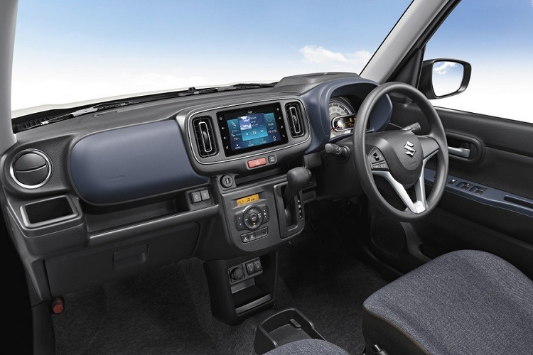 Vì là xe giá rẻ nên Suzuki Alto 2022 chỉ được được trang bị ghế bọc nỉ và không hề có bệ tì tay trung tâm. Bên cạnh đó là vô lăng mới, tích hợp phím chỉnh âm lượng hoặc kết nối Bluetooth. Đằng sau vô lăng, bảng đồng hồ có thêm màn hình LCD nhỏ nằm ngang, tạo cảm giác phức tạp hơn.