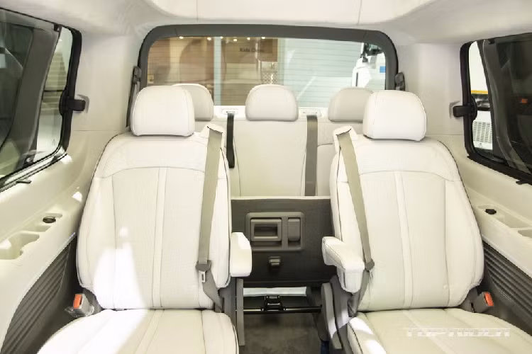 Chưa hết, ở giữa Hyundai Staria Lounge Limousine còn có cụm điều khiển trung tâm mới mang tên Universal Island, tích hợp 2 hộc đựng cốc. Cụm điều khiển trung tâm này đi kèm bàn gấp để hành khách phía sau ăn uống hoặc làm việc. Người dùng có thể tùy ý đẩy cụm điều khiển trung tâm này lên hàng ghế thứ nhất hoặc xuống phía sau. Khi muốn nâng cụm điều khiển trung tâm cao lên, hành khách chỉ cần bấm nút "Push" nằm cạnh hộc đựng cốc.