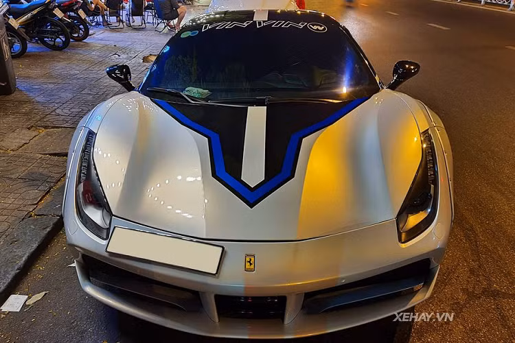 Ở phía bên ngoài, chiếc Ferrari 488 GTB độ Liberty Walk mới được chủ nhân thay đổi "bộ cánh" từ màu vàng/đen sang tông màu xám/xanh/đen xen lẫn. Nhìn bằng mắt thường có thể thấy, cách pha trộn màu sắc và thiết kế ngoại thất của xe được thực hiện rất công phu. Toàn bộ quá trình này được thực hiện bằng phương pháp dán đề-can cao cấp.