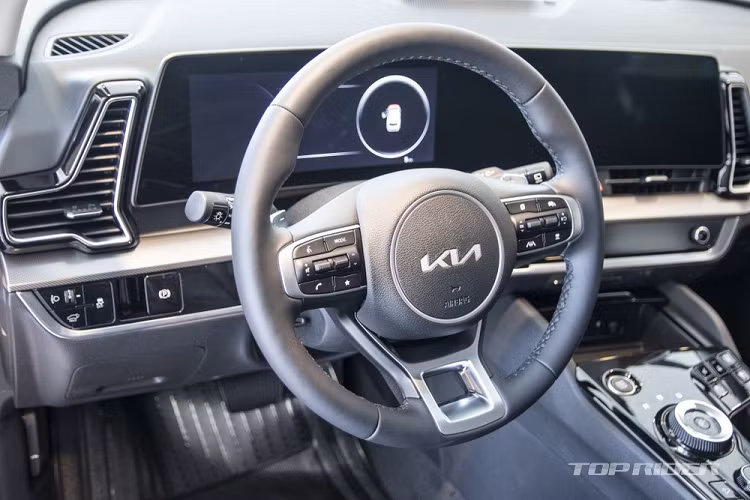 Bên dưới là hốc gió trung tâm khá rộng và đèn sương mù trước 2 tầng. Bao quanh hốc đèn sương mù trước là viền màu bạc làm điểm nhấn. Bên sườn Kia Sportage 2022 xuất hiện đường dập gân nổi bật, kéo dài từ hốc bánh trước đến cửa sau, đường chân kính mạ crôm kéo dài lên cột D và nóc xe màu đen. Tùy vào phiên bản, xe sẽ được trang bị 7 loại vành la-zăng có đường kính từ 17 - 19 inch.