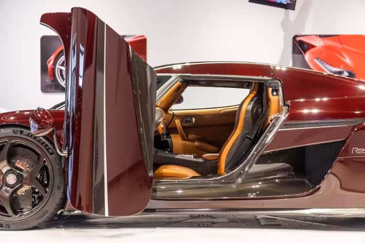 Chiếc xe Koenigsegg Regera được bạn thân của doanh nhân Hoàng Kim Khánh chia sẻ cho thấy ngoại thất xe được phủ hoàn toàn bằng sợi carbon, trong đó, sợi carbon đỏ là điểm nhấn chính của bộ áo này bên cạnh các sợi carbon nhám hay đen bóng.