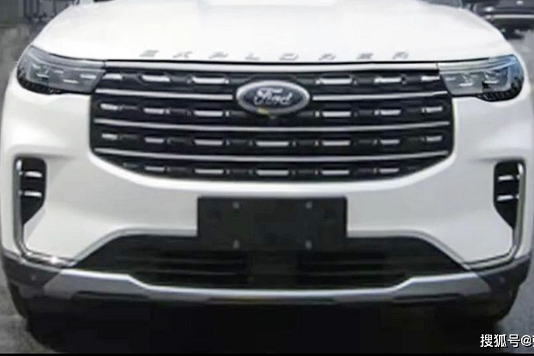 Lưới tản nhiệt của Ford Explorer 2022 nối liền với cụm đèn pha mới ở hai bên, tích hợp dải đèn LED định vị ban ngày. Trong khi đó, đèn sương mù trước không được thiết kế nằm ngang như cũ mà đặt trong hốc nằm dọc. Tiếp đến là viền mạ crôm kéo dài từ hốc đèn sương mù trước xuống hốc gió trung tâm và tấm ốp gầm giả màu bạc dưới cản trước.