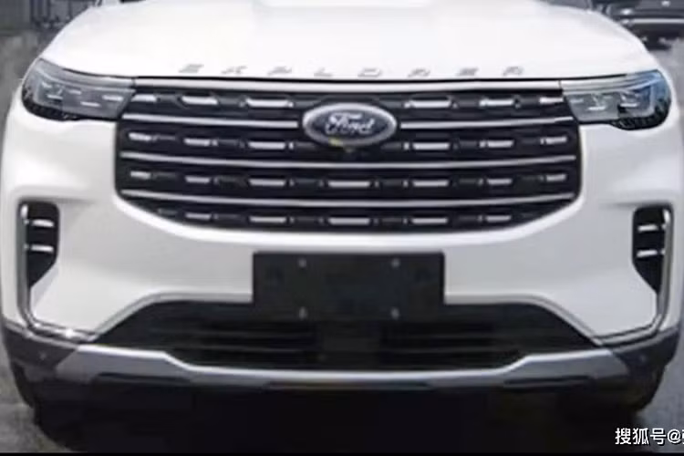 Lưới tản nhiệt của Ford Explorer 2022 nối liền với cụm đèn pha mới ở hai bên, tích hợp dải đèn LED định vị ban ngày. Trong khi đó, đèn sương mù trước không được thiết kế nằm ngang như cũ mà đặt trong hốc nằm dọc. Tiếp đến là viền mạ crôm kéo dài từ hốc đèn sương mù trước xuống hốc gió trung tâm và tấm ốp gầm giả màu bạc dưới cản trước.