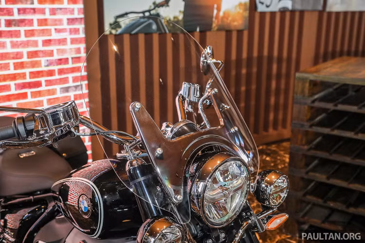 Nhìn từ phía trước, R 18 Classic trông ấn tượng hơn khi được lắp thêm kính chắn gió cùng 2 đèn sương mù, giúp giảm mệt mỏi cho người lái vì gió bạt và tăng tầm nhìn khi di chuyển ban đêm hoặc điều kiện thời tiết xấu. Bên cạnh đó, bánh trước có kích thước 130/90R16 thay vì cỡ 120/70R19 như trên bản First Edition. 