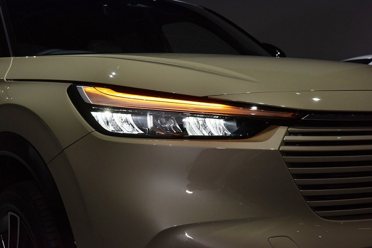 Lại nói đến đèn pha, Honda HR-V 2021 được trang bị loại mới có thiết kế thanh mảnh, vuốt về phía sau khá mượt mà. Bên trong cụm đèn pha này là dải đèn LED định vị ban ngày nằm trên cao, gợi liên tưởng đến cặp lông mày. Bên dưới nữa là hốc gió trung tâm với mắt lưới hình tổ ong và đèn sương mù trước nằm ngang. Hốc đèn sương mù được bao quanh bằng viền màu đen bóng.