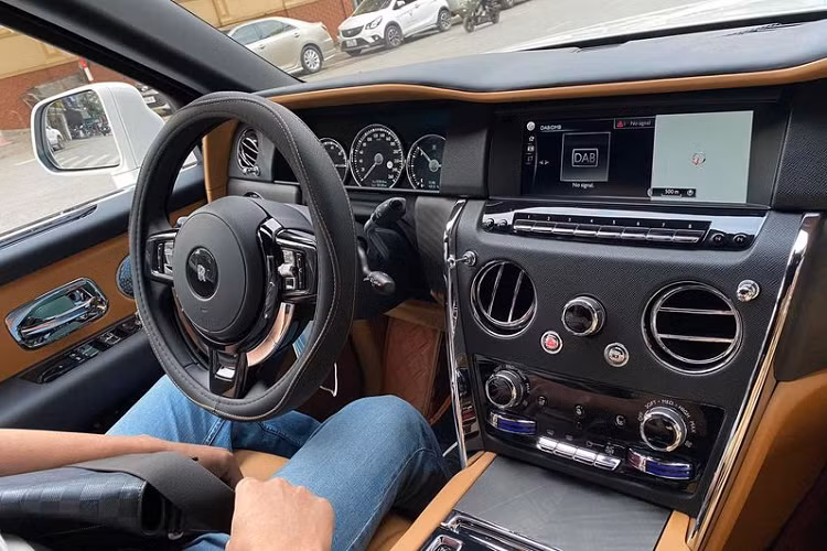 Ở bên trong, nội thất SUV siêu sang Rolls-Royce Cullinan được bọc da màu nâu kết hợp các chi tiết màu đen ở táp-lô, vô lăng, ốp cửa... Ngoài ra, chiếc Cullinan này cũng sở hữu nhiều trang bị đáng chú ý khác như màn hình giải trí cỡ lớn, đồng hồ dạng cơ và hàng loạt chi tiết ốp gỗ thủ công cao cấp.