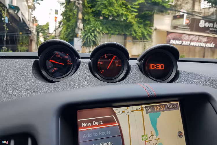 Màn hình giải trí trung tâm của 370Z NISMO dạng cảm ứng, cho phép người lái thao tác các tính năng vận hành và tiện nghi dễ dàng hơn. Bên trên là bộ 3 đồng hồ đặc trưng của 370Z, được dùng để đọc các chỉ số nhiệt độ dầu máy, hiệu điện thế và thời gian.