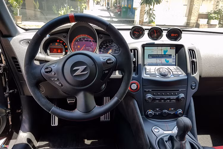 Vô lăng của xe được bọc da và Alcantara giúp tăng độ bám khi sử dụng. Bảng đồng hồ cơ kết hợp cùng màn hình thông báo nhỏ cho phép hiển thị tốc độ và vòng tua một cách tối giản nhất. Điểm đặc biệt là khi người lái điều chỉnh vô lăng, bảng đồng hồ cũng xe di chuyển theo.