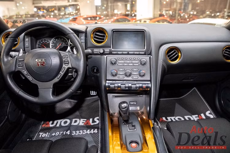 Trên thực tế, chiếc GT-R ở ảnh đây không hề có thân vỏ mạ vàng hoặc chạm khắc thật, bởi không phải phần nào của thân vỏ cũng bằng kim loại. Về bản chất, nó là một bộ widebody kit có thiết kế đặc biệt và có đi kèm một cánh gió lớn phía sau. Ngoài ra, chiếc xe còn có bộ la-zăng cực lớn và ống xả titan để tăng thêm độ hấp dẫn.