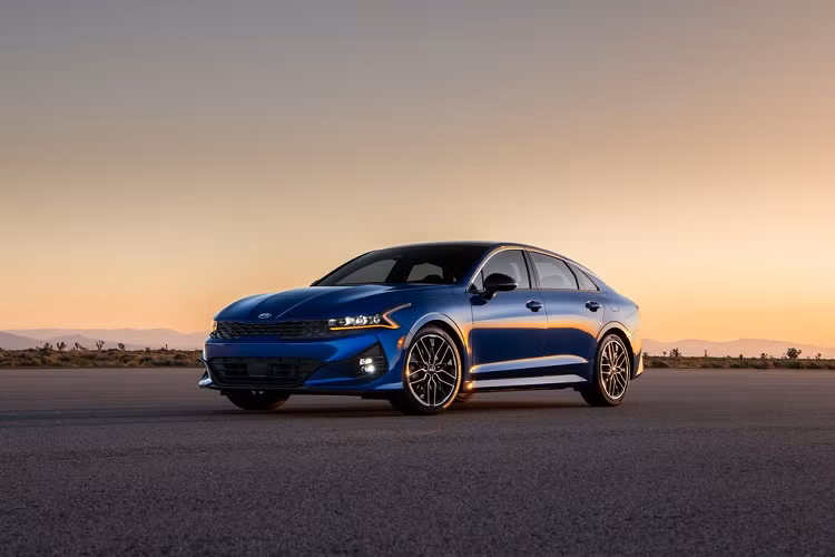 Về phần thiết kế, khi so sánh với phiên bản tiền nhiệm, Kia K5 2021 sở hữu một phong cách thiết kế hoàn toàn mới, mang đậm giá trị mà Kia đang theo đuổi. Kiểu thiết kế trên Kia K5 2021 được đánh giá là khá cầu kỳ với nhiều chi tiết bắt mắt như bộ lưới tản nhiệt hình mũi hổ thế hệ mới, hệ thống đèn pha LED với đèn định vị thanh mảnh cùng tạo hình ấn tượng. Thêm vào đó, trên nắp ca-pô của xe cũng không thiếu đi những đường gân dập nổi tổ điểm cho vẻ nam tính và thời trang của chiếc xe.