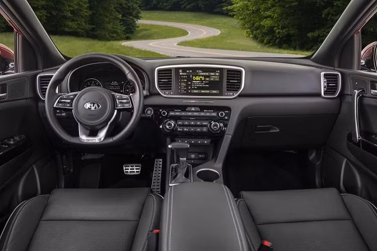 Chưa hết, Kia Sportage 2021 còn có hốc gió trung tâm khá rộng bên dưới, đi kèm tấm ốp gầm màu bạc hầm hố. Thêm vào đó là hốc đèn sương mù trước hình ngũ giác khá lớn, được sơn màu đen bóng. Bên sườn, Kia Sportage 2021 tiếp tục được áp dụng những đường kẻ thẳng thớm như SUV truyền thống. Tương tự như vậy, mẫu SUV cỡ C này còn có nẹp bằng nhựa màu đen bao quanh thân xe.