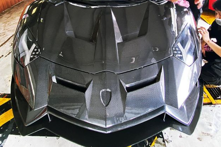 Sau gần ba tháng bắt tay vào "lột xác", chiếc Lamborghini Aventador LP700-4 độ Duke Dynamics đầu tiên ở dải đất hình chữ S đã ra lò với ngoại hình hầm hố. Cụ thể, không để chiếc Aventador LP700-4 độ Duke Dynamics này mang bộ áo sợi carbon trần, sẽ khó phối màu với lại bên hông xe cũng như nóc xe có màu vàng nguyên bản, thay vào đó, chủ nhân đã chọn cách đổi áo mới bằng đề-can với màu rằn ri rất ấn tượng và nổi bật cho bò tót này. 