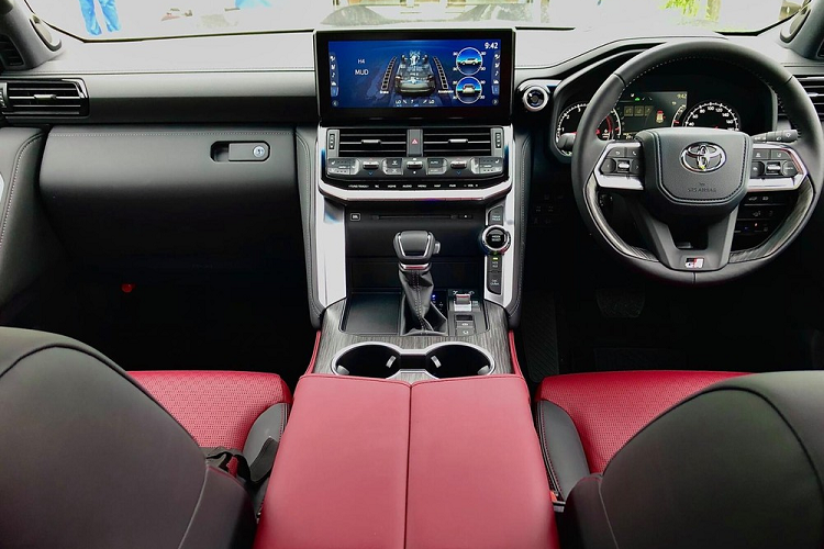 Bên trong Toyota Land Cruiser GR Sport 2022 là không gian nội thất bọc da màu đỏ phối đen tương phản. Xe có những trang bị đáng chú ý như bảng đồng hồ kết hợp giữa kỹ thuật số và analogue, vô lăng bọc da phối ốp gỗ, cần số bọc da, sạc điện thoại thông minh không dây, 2 hàng ghế trước đủ tính năng sưởi ấm/làm mát, ngăn làm mát đồ uống bên dưới bệ tì tay trung tâm hàng ghế trước, hệ thống lọc không khí Nano X...