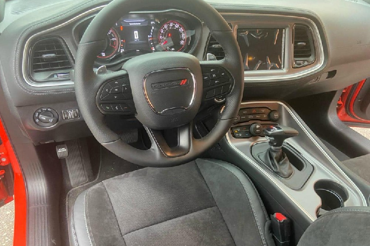 Nắp capô chiếc xe Dodge Challenger GT có thêm 1 khe gió lồi đúng chất cơ bắp của các mẫu xe thể thao đến từ Mỹ. Điểm ấn tượng của chiếc Dodge Challenger GT đang được chào bán hơn 3 tỷ đồng chính là việc sở hữu hệ thống radar phía trước. Vòng ra bên hông xe có thể thấy phiên bản Dodge Challenger GT tạo điểm nhấn với các vòm bánh xe mở rộng cùng bộ mâm 5 chấu kép sơn đen bóng tạo điểm nhấn. Nắp bình xăng của xe được sơn tối màu tạo tính tương phản bộ áo đỏ của xe.