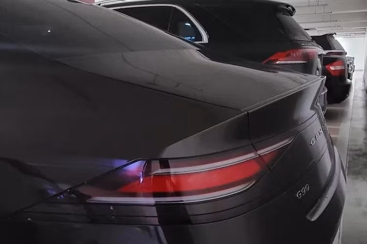 Ở đằng sau, Genesis G90 2022 không được trang bị cụm đèn hậu với 2 dải đèn LED song song như đèn pha. Thay vào đó là cụm đèn hậu LED thanh mảnh và góc cạnh, nối liền với nhau. Bên dưới đèn hậu còn có một dải đèn nữa, kéo dài sang chắn bùn sau khiến đuôi xe trông như rộng hơn. Chưa hết, Genesis G90 2022 còn nẹp xung quanh thân xe, tích hợp đèn phản quang nằm ngang trên cản sau. Cuối cùng là 2 đầu ống xả giả hình chiếc khiên giống lưới tản nhiệt