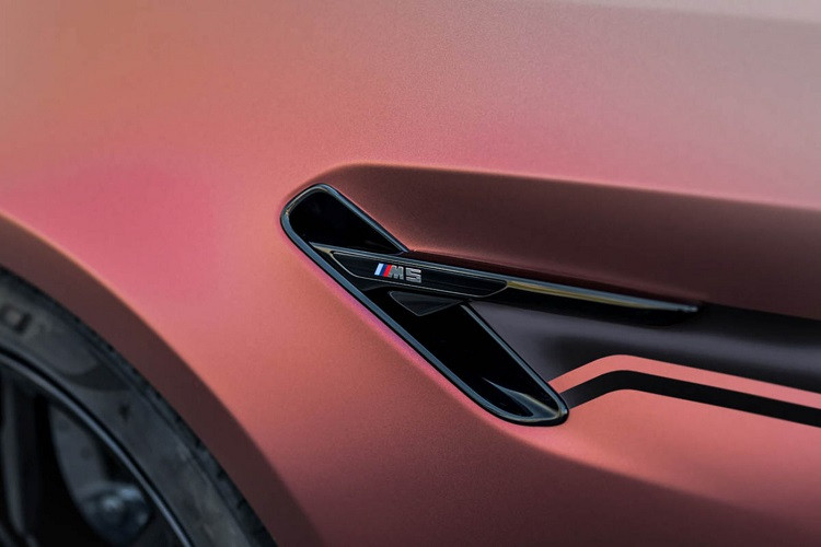 Thay vì ngoại thất màu đen bóng cùng những họa tiết màu vàng Gold đặc trưng của những bản độ từ Manhart, thương hiệu lần này lại lựa chọn “khoác” lên cho MH5 800 lớp decal màu hiệu ứng với bề mặt hoàn thiện sần và đổi màu theo góc nhìn. Thương hiệu cũng trang bị thêm đường decal tạo điểm nhấn dọc xe giống các phiên bản độ khác được “ra lò” từ xưởng độ Manhart.