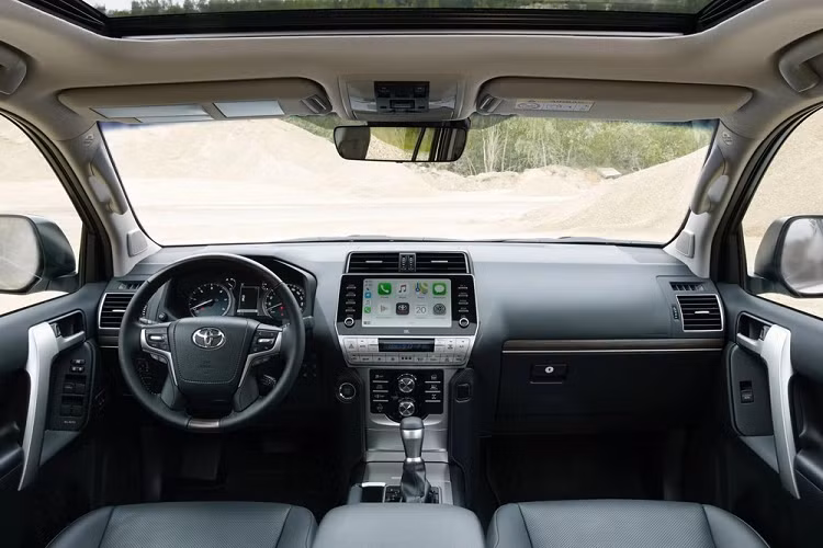 Thuộc bản nâng cấp giữa vòng đời, thiết kế của Toyota Land Cruiser Prado 2021 không có nhiều thay đổi so với đời cũ và mức tăng giá 120 triệu đồng sẽ đi kèm nhiều trang bị hấp dẫn. Cụ thể, xe sẽ có mâm hợp kim 19 inch lớn hơn đời cũ, giá nóc, nội thất có thêm lẫy chuyển số sau vô lăng, đề nổ nút bấm, màn hình giải trí mới, hệ thống âm thanh 14 loa JBL.