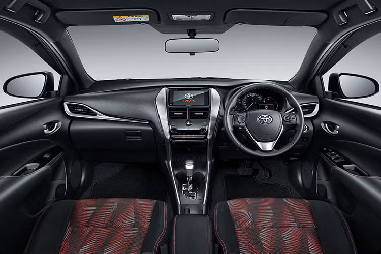 Bước vào bên trong Toyota Yaris GR Sport 2022, người lái được chào đón bằng không gian nội thất màu đen phối đỏ tương phản. Vô lăng bọc da, ghế bọc nỉ, bệ tì tay trung tâm và mặt cửa đều đi kèm chỉ khâu màu đỏ. Thêm vào đó là màn hình cảm ứng 7 inch của hệ thống thông tin giải trí, hỗ trợ kết nối với điện thoại thông minh qua Apple CarPlay và Android Auto.