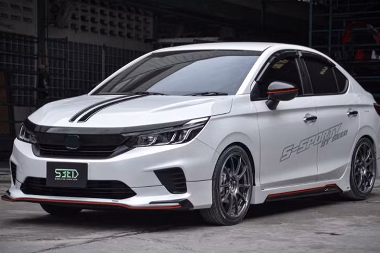 Bộ sản phẩm bodykit độ Honda City 2021 này bao gồm phần líp cản trước mới, các chi tiết màu đen và đỏ bóng, phần ốp sườn giả sợi carbon. Ốp gương chiếu hậu sơn đen cùng sọc đỏ ở giữa.
