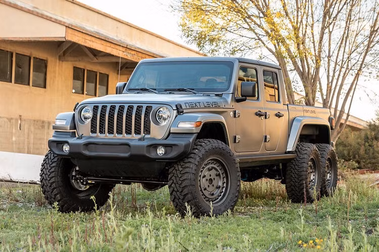 Sau khi nâng cấp, ngoại hình của chiếc Jeep Gladiator 6x6 Next Level không quá khác biệt so với xe nguyên bản. Mẫu bán tải vẫn có các chi tiết nhận diện đặc trưng của Jeep như lưới tản nhiệt gồm 7 thanh dọc, đèn chiếu sáng tròn, đèn định vị và xi-nhan nằm trên vòm bánh trước...