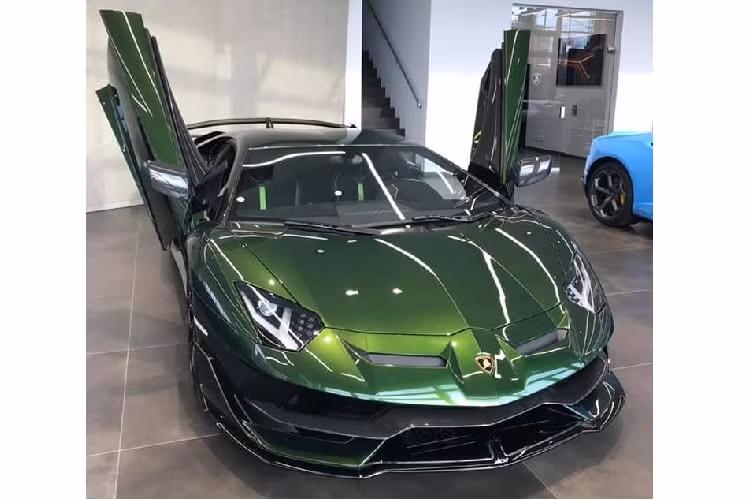Nhìn bên ngoài chiếc siêu xe hàng hiếm Lamborghini Aventador SVJ Coupe sắp về Việt Nam được phủ lên ngoại thất bộ áo màu xanh rất độc đáo và đẹp mắt. Đi kèm còn có nhiều chi tiết carbon. Bên trong khoang lái xe có ghế ngồi bọc da Alcantara màu tối và sọc là xanh lá cây nổi bần bật.