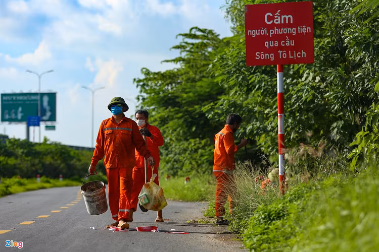 Công nhân Công ty Cổ phần Quản lý và xây dựng đường bộ I Hà Tây cắm biển cảnh báo cấm đi lại trên các ngả ở đường gom cao tốc, chiều 5/9. 