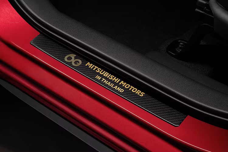 Mở cửa bước vào khoang lái, vị trí bước chân được dán một tấm nẹp chống trầy làm từ chất liệu giống carbon với huy hiệu kỷ niệm 60 năm thành lập Mitsubishi Motors Thái Lan.