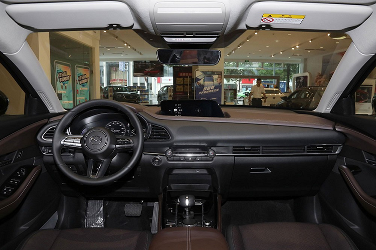 Tiếp đến là kính cửa sổ của xe khá hẹp với nẹp mạ crôm, baga nóc và cửa sổ trời. Đằng sau, Mazda CX-30 EV được trang bị đèn hậu LED giống CX-30. Trong khi đó, cản sau của xe được thiết kế mới theo phong cách tương đồng với cản trước.