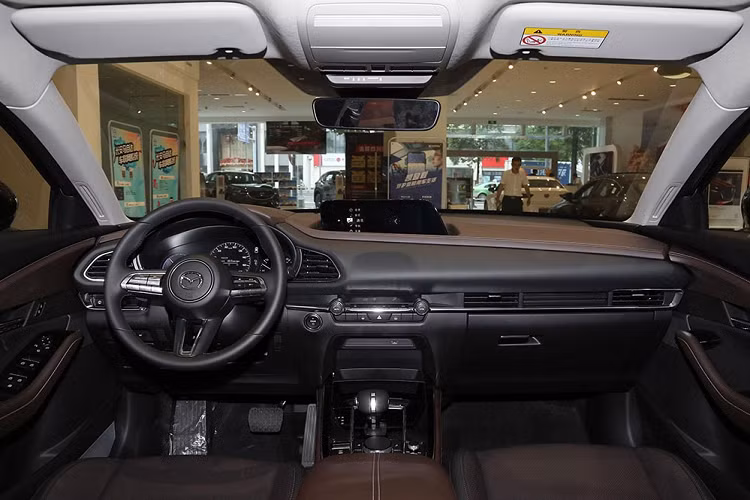 Tiếp đến là kính cửa sổ của xe khá hẹp với nẹp mạ crôm, baga nóc và cửa sổ trời. Đằng sau, Mazda CX-30 EV được trang bị đèn hậu LED giống CX-30. Trong khi đó, cản sau của xe được thiết kế mới theo phong cách tương đồng với cản trước.