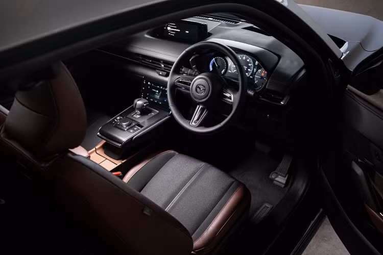 Nội thất MX-30 trang bị màn hình hiển thị thông tin lái xe TFT 7 inch, màn hình thông tin giải trí 8,8 inch tương thích Apple CarPlay và Android Auto, định vị vệ tinh,...Ghế bọc da hai tông màu với ghế trước chỉnh điện tích hợp sưởi ghế và nhớ ghế. Vô lăng có sưởi. Điều hòa trên xe loại kiểm soát khí hậu một vùng.