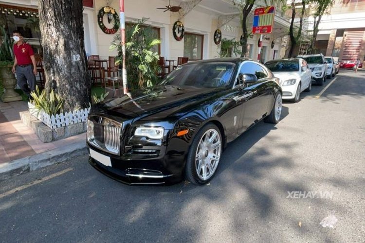 Chiếc xe siêu sang Rolls-Royce Wraith của doanh nhân đam mê siêu xe gốc Gia Lai sở hữu ngoại thất màu đen lịch lãm kết hợp với các điểm nhấn crôm sáng bóng như lưới tản nhiệt đặc trưng phía trước, viền cửa sổ, nẹp trang trí bên hông...