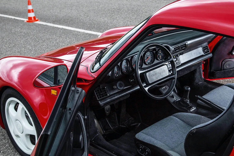 Tuy nhiên, Porsche 959 bị cấm nhập khẩu vào Mỹ do không có giấy chứng nhận đạt chuẩn của NHTSA. Nguyên nhân chính đến từ việc hãng xe Đức không cung cấp 4 xe 959 để NHTSA thực hiện bài thử nghiệm va chạm. Bill Gates đã đấu tranh để chiếc xe có thể được nhập vào Mỹ qua diện trưng bày và chỉ có thể lăn bánh 2.500 dặm/năm. Ảnh: DriveTribe.