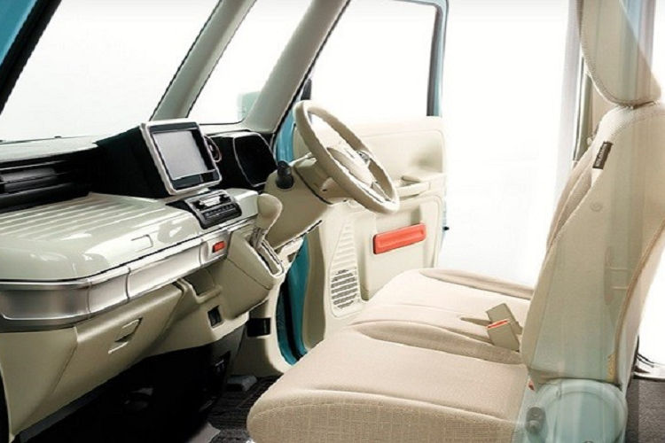 Dưới nữa là hốc gió trung tâm cỡ lớn với mắt lưới hình tổ ong màu đen và đèn sương mù hình tròn khá nhỏ ở hai bên. Hốc gió trung tâm và đèn sương mù đều được bao quanh bằng viền màu đen dày dặn. Ở bên sườn, Mazda Flair Wagon 2022 bản Tough có nẹp màu đen trên cửa, bậc cửa và vành la-zăng thể thao hơn cũng như baga nóc. Trong khi đó, ốp gương ngoại thất, tay nắm cửa và nóc đều được sơn màu đen.