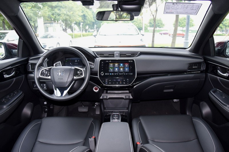 Nẹp mạ crôm kể trên nối liền với cụm đèn pha hai bên. Đèn pha chính của xe được bao quanh bằng dải đèn LED định vị ban ngày. Bên dưới là hốc gió trung tâm hình thang ngược và 2 đèn sương mù hình tròn, nằm trong hốc màu đen. Nhìn chung, thiết kế đầu xe của Honda Crider 2022 tạo cảm giác tròn trịa và đầy đặn hơn trước.